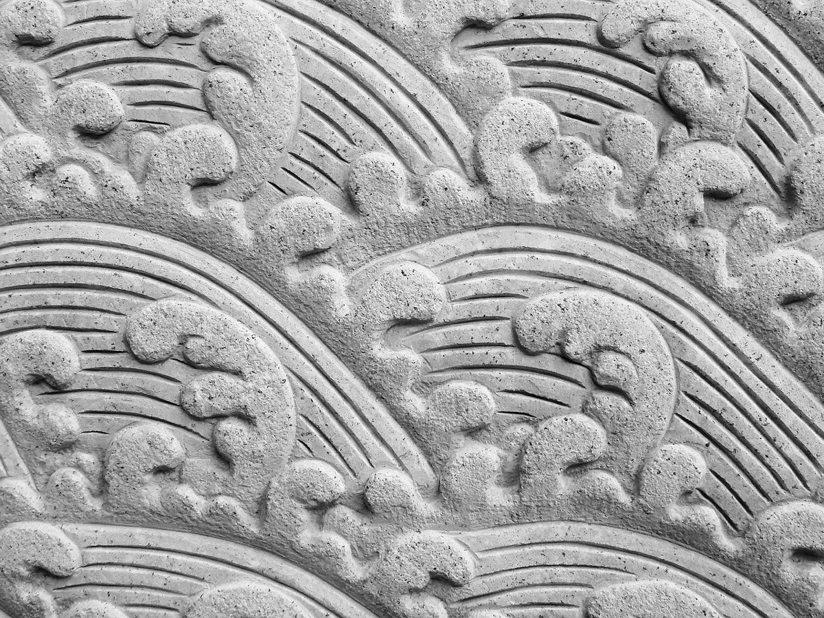 Wooden sculpture with intricate carvings of a winding path in a gallery setting
